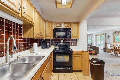 a kitchen with a sink and a stove top oven at White Mountain Getaway in Bartlett