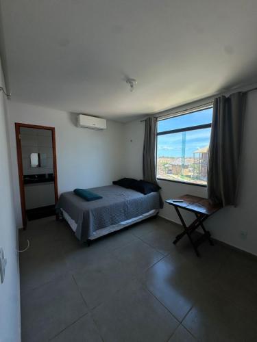 a bedroom with a bed and a large window at Chaleville Maramar in Luis Correia