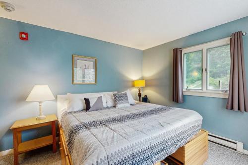 a blue bedroom with a bed and a window at Snowcone in Bartlett