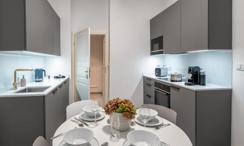 a kitchen with a table and chairs in a kitchen at River Dance Suites by Adrez in Prague