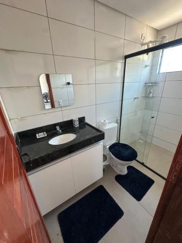 a bathroom with a sink and a toilet at Chaleville Maramar in Luis Correia