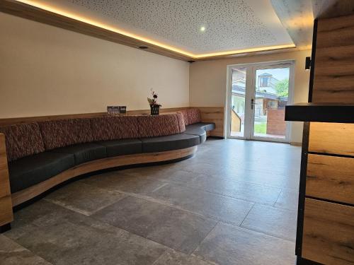 a waiting room with a couch in the middle of the room at first mountain Hotel Zillertal in Aschau