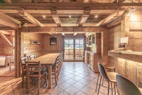 une salle à manger avec une table et des chaises en bois dans l'établissement Chez Merlin, à Glières-Val-de-Borne