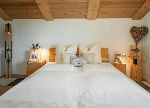 a bedroom with two white beds and wooden ceilings at Ferienwohnung Allgäutraum mit Bergblick in Oy-Mittelberg