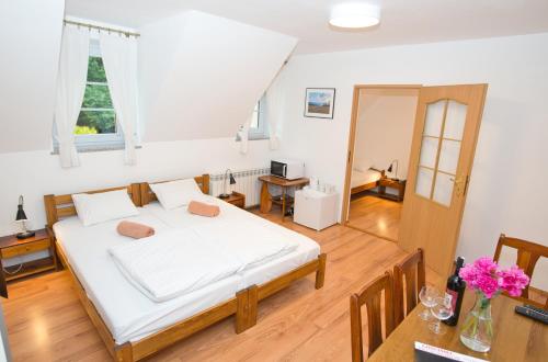 a bedroom with a large bed and a table at Gościniec Pięciu Stawów in Ustrzyki Dolne
