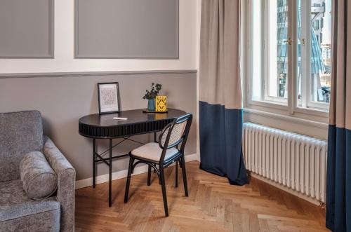 a small table in a room with a chair and a window at River Dance Suites by Adrez in Prague
