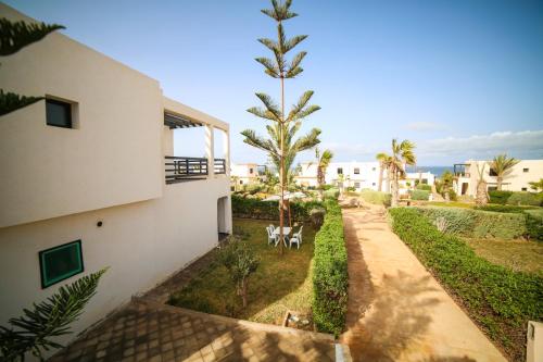 an external view of a building with palm trees at Villa Agloucenter in Zaouia Sidi Ouaggag