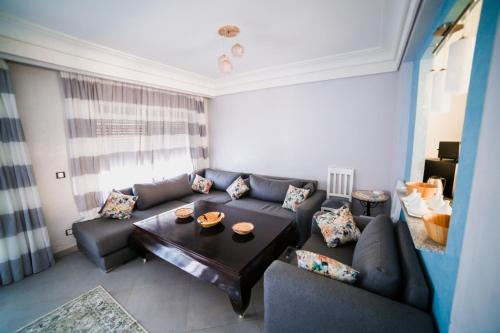 a living room with a couch and a table at Villa Agloucenter in Zaouia Sidi Ouaggag