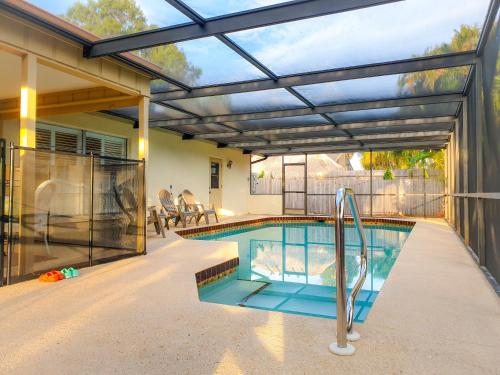 a swimming pool with a pergola over it at Comfortable home, heated salt-cell pool, 10 min to beach in Sarasota
