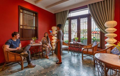 a man and a woman sitting in a waiting room at Cozy Savvy Hoi An - The Quintessence of Exquisite Retreat in Hoi An