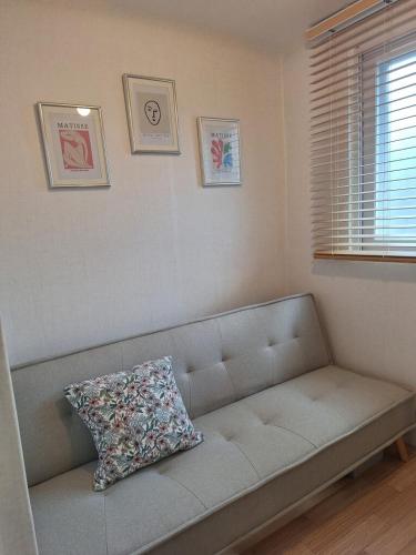 a couch in a living room with a pillow on it at Stay Hyuga Suwon in Suwon