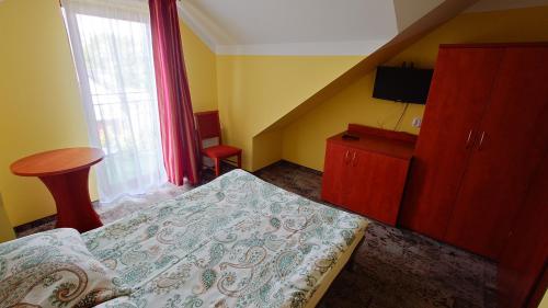 a bedroom with a bed and a dresser and a window at Rafa in Trzęsacz