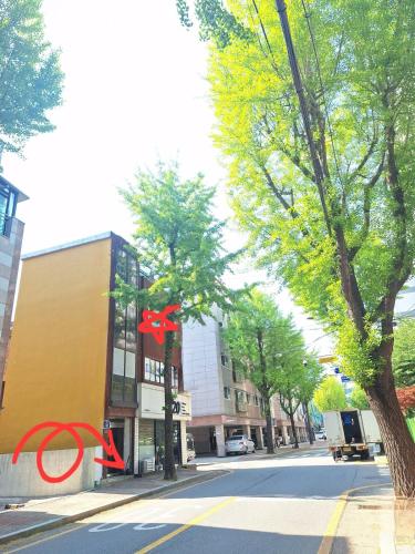 a red bow tied to a tree on a city street at Stay Hyuga Suwon in Suwon