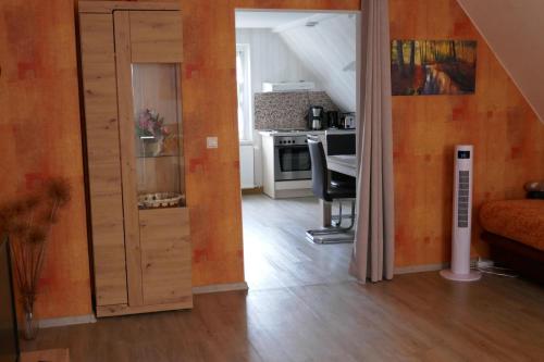 ein Wohnzimmer mit Tür und eine Küche in der Unterkunft Ferienwohnung Edelweiß im Erzgebirge in Markersbach