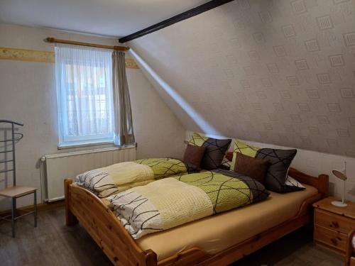 ein Schlafzimmer mit einem Bett und einem Fenster in der Unterkunft Ferienwohnung Edelweiß im Erzgebirge in Markersbach