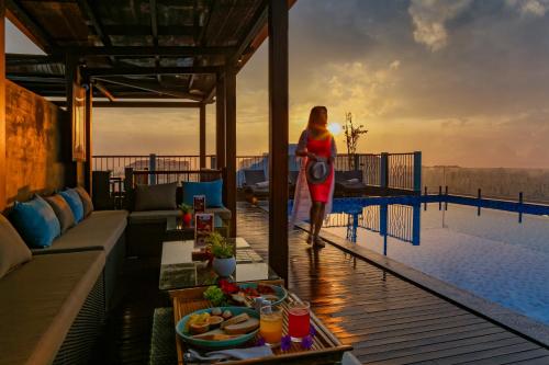a woman walking on the deck of a house at Cozy Savvy Hoi An - The Quintessence of Exquisite Retreat in Hoi An