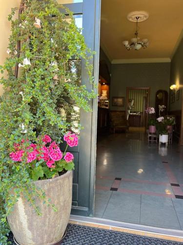 a large planter with pink flowers in a lobby at Villa Antica in Kudowa-Zdrój
