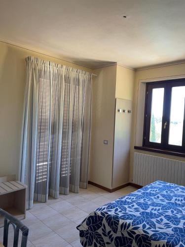 a bedroom with a bed and a large window at villa Diamante in Lamporecchio
