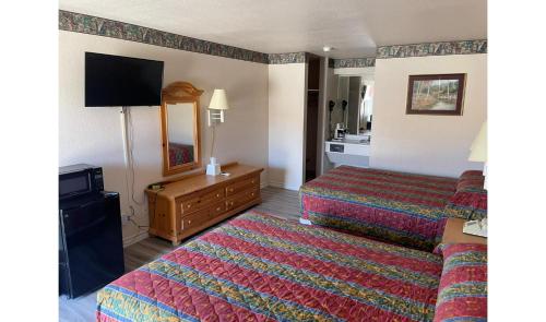 a hotel room with two beds and a flat screen tv at Lakeside inn & suites by OYO Mathis I 37 in Mathis