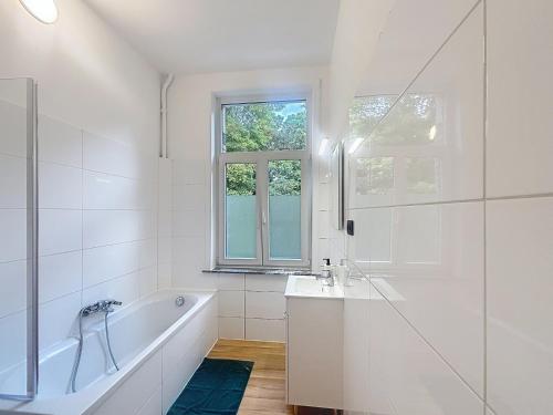 a bathroom with a tub and a sink and a window at Leopold Brussels 6 in Brussels