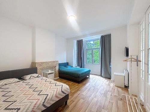 a bedroom with a bed and a couch and a window at Leopold Brussels 6 in Brussels