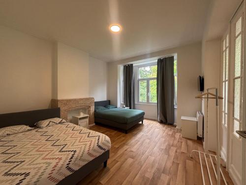 a bedroom with a bed and a couch and a window at Leopold Brussels 6 in Brussels