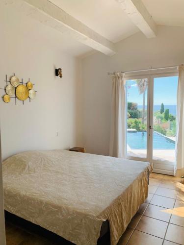 une chambre avec un lit et une grande fenêtre dans l'établissement Villa Fleur Oranger Issambres, vue mer, 15mn plage, aux Issambres