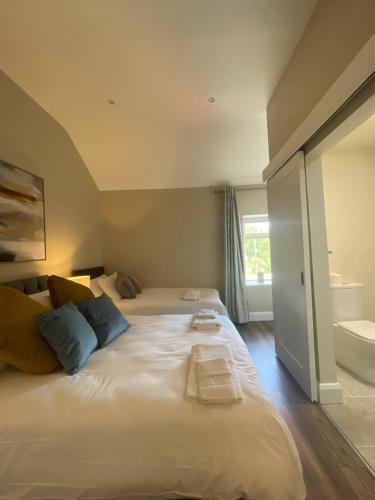 a large white bed in a room with a bathroom at The Oyster House in Clarinbridge