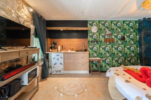 Cette chambre comprend une cuisine et un lit. dans l'établissement Le Vésuve avec jaccuzi, à Saint-Genis-de-Saintonge