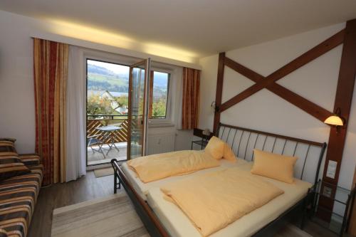a bedroom with a bed and a large window at Hotel Kollerhof in Aich
