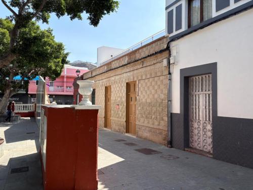 a brick building with a gate and a street at Casas La Aldea Suites Plaza 3 in La Aldea de San Nicolas
