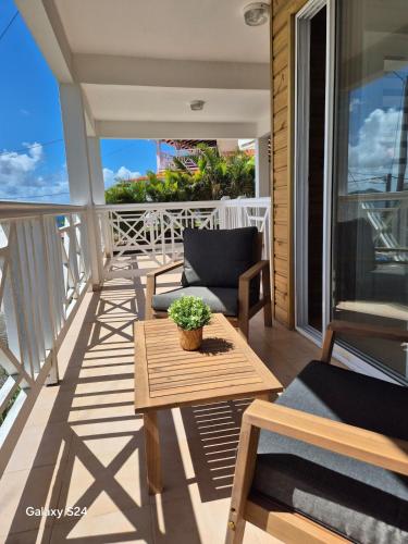 a patio with a table and chairs on a balcony at F2 magnifique vue mer in Le Robert