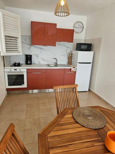 a kitchen with a table and a kitchen with red cabinets at F2 magnifique vue mer in Le Robert