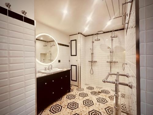a bathroom with a sink and a shower with a mirror at Grand Deluxe Poule Noire in Égreville