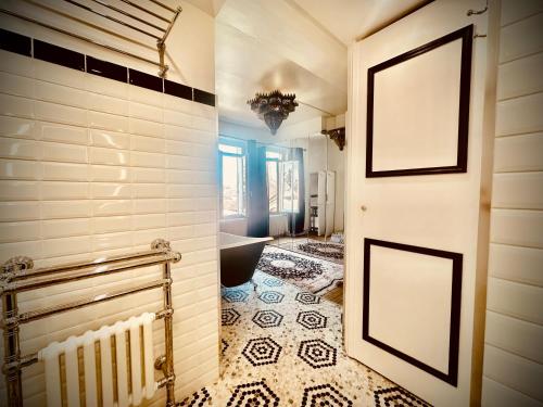 a bathroom with a door and a tile floor at Grand Deluxe Poule Noire in Égreville