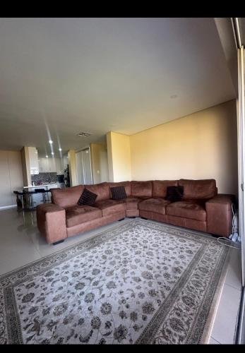 a brown couch in a living room with a rug at Tamboti in Vosburg