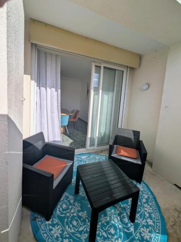a living room with two chairs and a table at "La Planque" T4 en plein centre, calme et lumineux - Terrasse & parking in Valence