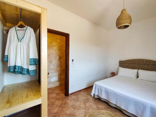 a bedroom with a bed and a dress hanging on a door at La Cupola di Casa Camilla Journey in Tricase