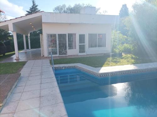 a house with a swimming pool in front of a house at Casa vista panorámica al lago in Cordoba