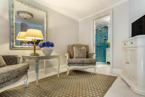 a living room with a table and a chair and a mirror at Hotel Bardot Boutique in Panama City
