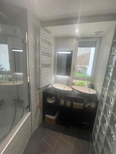 une salle de bain avec deux lavabos et une douche dans l'établissement Appartement style galerie d'art avec parking, à Paris