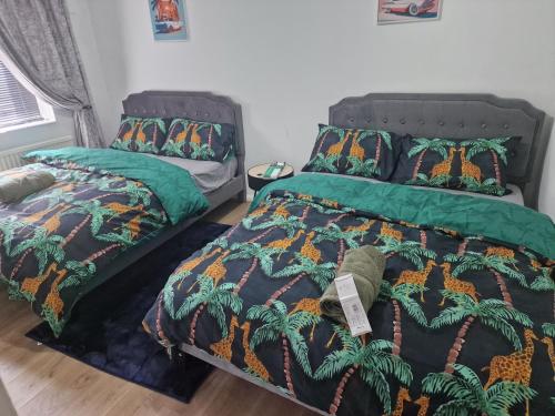 a bedroom with two beds with green comforters at E13 x DM4 weekly monthly deals in London