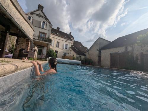 une femme est assise dans une piscine dans l'établissement Poule Noire Ukraine, à Égreville