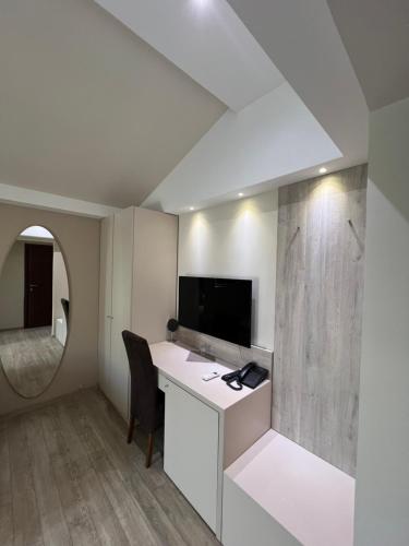 a room with a desk with a television and a chair at Hotel Holiday in Podgorica