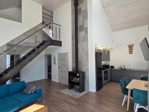 un salon avec un canapé bleu et un escalier dans l'établissement Kambarių nuoma Naujojoje Akmenėje, à Naujoji Akmenė