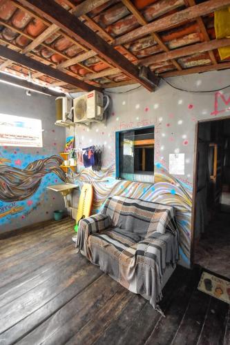 a room with a bed and a mural on the wall at Rota Itacaré Surf Hostel in Itacaré