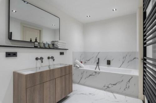 a bathroom with a tub and a sink and a mirror at Charming Stay De Pijp at Centrum in Amsterdam