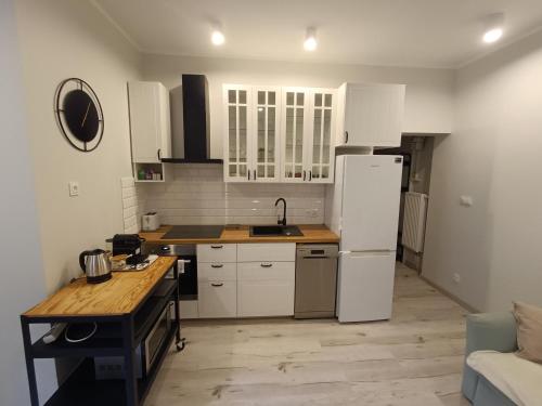 a kitchen with white cabinets and a white refrigerator at Apartament Park&Stadion in Szczecin