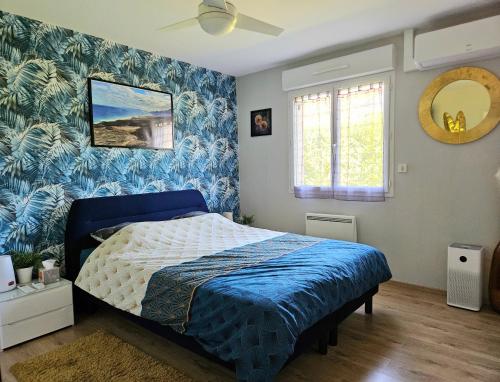 a bedroom with a bed with a blue and white bedspread at Maison très bien équipée avec piscine et au calme in Bourg-en-Bresse