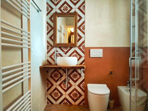 a bathroom with a toilet and a mirror at La Cupola di Casa Camilla Journey in Tricase